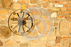 Old wooden wheel hanging on the wall.