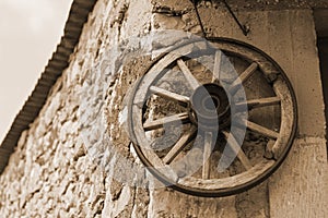 Old wooden wheel on a wall of