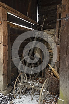 Old wooden wheels and gates and plow in barn