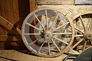 Old wooden wheels from grandfather`s cart are stored in a rustic barn