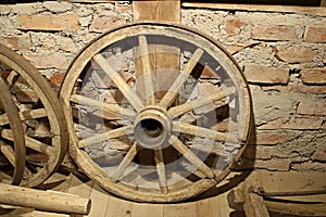 Old wooden wheels from grandfather`s cart are stored in a rustic barn