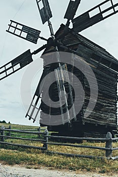 Old wooden wind mill on a grass lawn