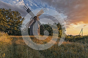 Old wooden windmill at dramatic sunset, historic outdoor background