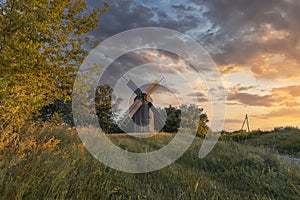 Old wooden windmill at dramatic sunset, historic outdoor background