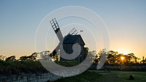 Old wooden windmill at dramatic sunset, historic outdoor background