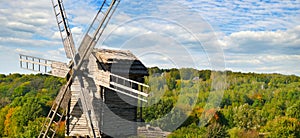 Old wooden windmill in field and sky