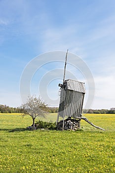 Old wooden windmill on grass field