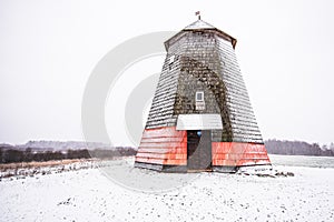 Old wooden windmill in snowy winter day, Kiras, Latvia. Restoration of the mill has begun
