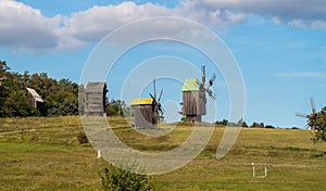 Old wooden windmills in meadow on sunny day