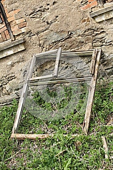 Old wooden window frame leant by devastated house