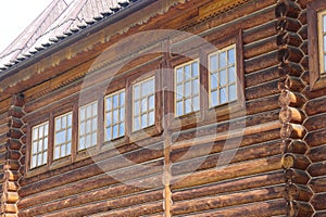 Old wooden window frame. Old window of an old wooden house. Background of wooden log walls
