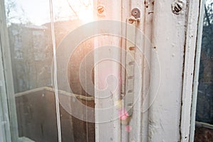 Old wooden window frame in winter or early spring with sun rays