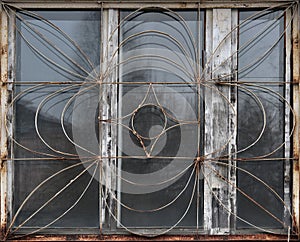 An old wooden window with a metal grille. The texture of the window frame.