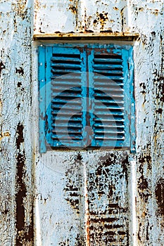 Old wooden window painted blue with rusty lock. Texture, wall of an old wooden house with shuttered windows, painted blue.