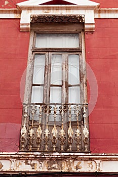Old wooden window with rusty balustrade in a historic building.