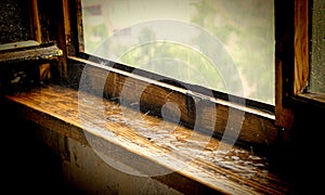 Old wooden window sill under a pouring rain
