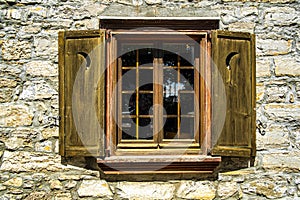Old wooden window with two shutters and stone wall in the city of Pointe Claire