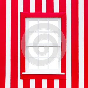 Old wooden window with white frame on the background of the striped red and white wall. Portugal Windows. The exterior