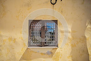 Old window on a yellow wall