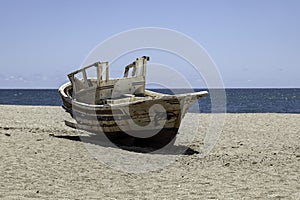 old wooden worn fishing boats abandoned on the beach of Cabo de Gata, Almeria, Spain.