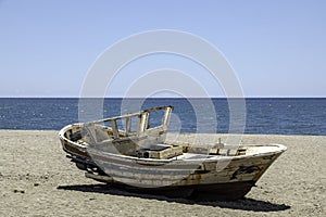 old wooden worn fishing boats abandoned on the beach of Cabo de Gata, Almeria, Spain.