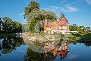 Old woodwn house reflected in the moat