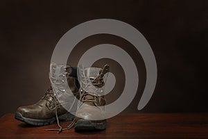 Old Work Boots On Brown Background With Copy Space