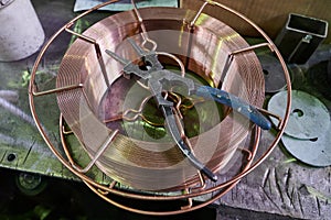 old working strong steel pliers for working on metal in the shop of the plant lie on a coil of copper wire of a large