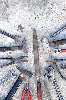 Old working tools on a concrete surface, top view