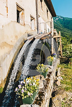 Old working watermill wheel with falling water