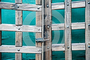 Old world wooden gate in front of green doors