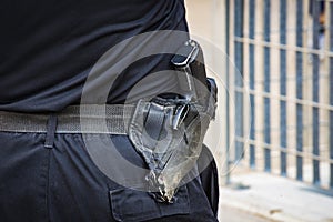 Old worn automatic gun on a policeman`s belt on the background photo