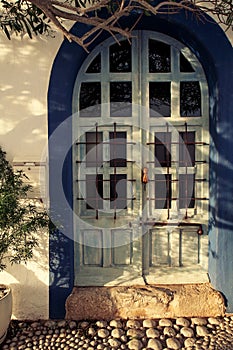 Old and worn blue wooden door with glass and ironwork in Ibiza island - Image