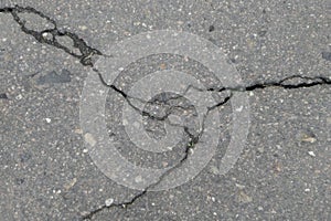 Old worn and cracked asphalt with cracks. Asphalt pavement road was damaged