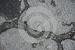 Old worn and cracked asphalt with cracks. Texture of a damaged road surface