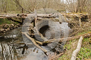 An old, worn, dangerous wooden bridge over a small river