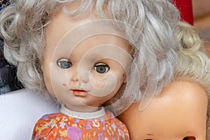 An old worn doll with dirty face close up, spooky view