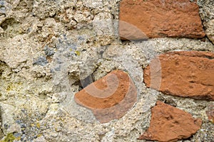 Old Worn Down Brick Wall with Plaster and Moss. Grunge Red Stonewall Background, Texture. Shabby Building Facade