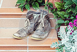 Old worn out boots at doorstep