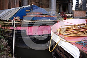 old worn out canal barges with rusty hulls and peeling paint