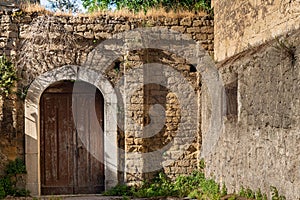 Old worn-out doors in a historic stone house of the 18th-19th centuries. Travel to European cities, southern Italy, old retro