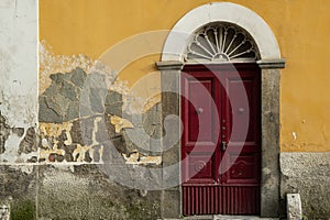 Old worn-out doors in a historic stone house of the 18th-19th centuries. Travel to European cities, southern Italy, old retro