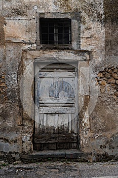 Old worn-out doors in a historic stone house of the 18th-19th centuries. Travel to European cities, southern Italy, old retro