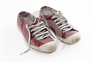 Old worn red sports shoes sneakers with laces