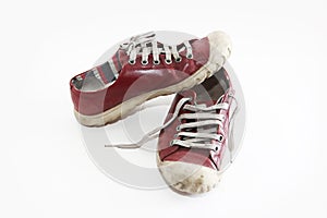 Old worn red sports shoes sneakers with laces