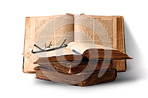 Old worn shabby jewish books in leather binding and open blurred Torah in the background. Closeup. Selective focus