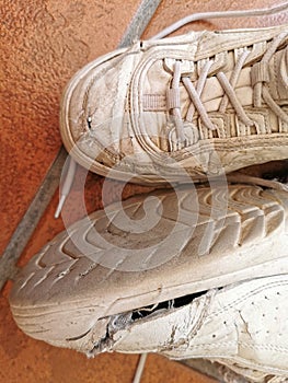 Old worn sneakers torn on the tiled floor