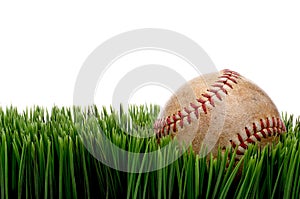 An old worn sports baseball on grass