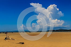 Old wreck fishing boat buried in the sand with blue sky on cloud