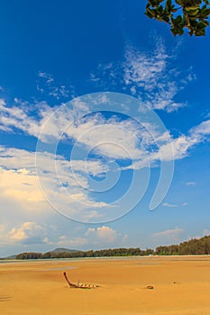 Old wreck fishing boat buried in the sand with blue sky on cloud